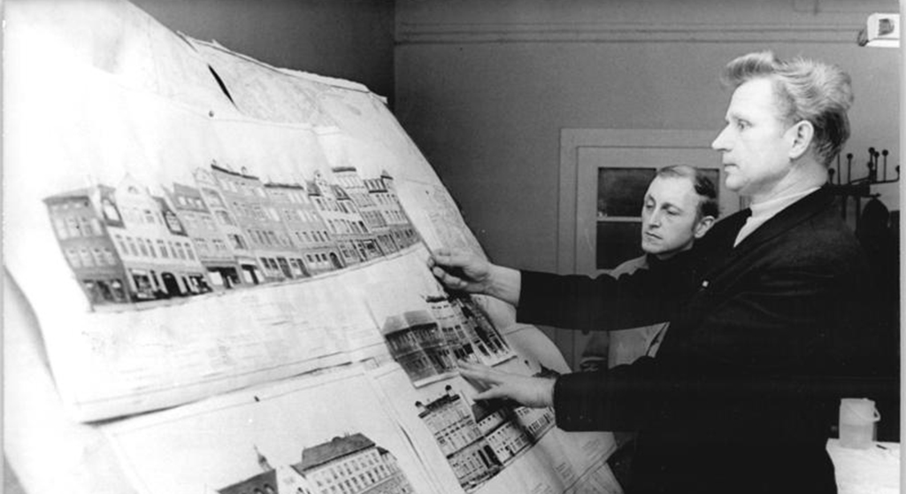 Zentralbild Gahlbeck 18.2.1970 Altenburg-Bez. Leipzig: Wahlen - Grofle Initiative der Werkt‰tigen und Einwohner. als Stadtarchitekt und Abgeordneter des Stadtparlamentes ist Werner Heidrich (Vordergrund) in seiner Stadt bekannt. Er ist Vorsitzender der St‰ndigen Kommission Bauwesen und Mitglied der LDPD. Zu seiner gegenw‰rtigen Hauptaufgabe gehˆrt die komplexe Verschˆnerung der gesamten Altstadt. Unter Zugrundelegung von dokumentarischen Aufnahmen gestaltet er gegenw‰rtig die Farbkonzeption f¸r die Renovierung ganzer Straflenz¸ge. Werner Heidrich ist seit einer Wahlperiode Abgeordneter und kandidiert wieder f¸r die Stadtverordnetenversammlung. Information Altenburg - seit dem 11. Jahrhundert erstmalig sicher erw‰hnt - erbl¸hte nach 1945 zu einer sozialistischen Stadt. 45 Betriebe aller Eigentumsformen vereinen heute ihre Mittel und Kr‰fte f¸r die effektivste Lˆsung der Planaufgaben. K¸rzlich wurde ein Komplexvertrag zwischen dem Rat, der ¸ber 50.000 Einwohner z‰hlenden Stadt (1818-10,160 E.), und den Betrieben vor dem Plenum der Stadtverordnetenversammlung unterzeichnet. Die Betriebe stellten mehr als 2 Millionen Mark zur Verf¸gung. Es entstanden neue Wohnensemble, ein Volkspark wurde geschaffen, in dem zur Zeit eine moderne Schwimmhalle mit Milchbar entsteht. Die Mittel wurden auch f¸r die Schaffung von 35 Kinderkrippen - und 220 Kindergartenpl‰tzen verwendet.