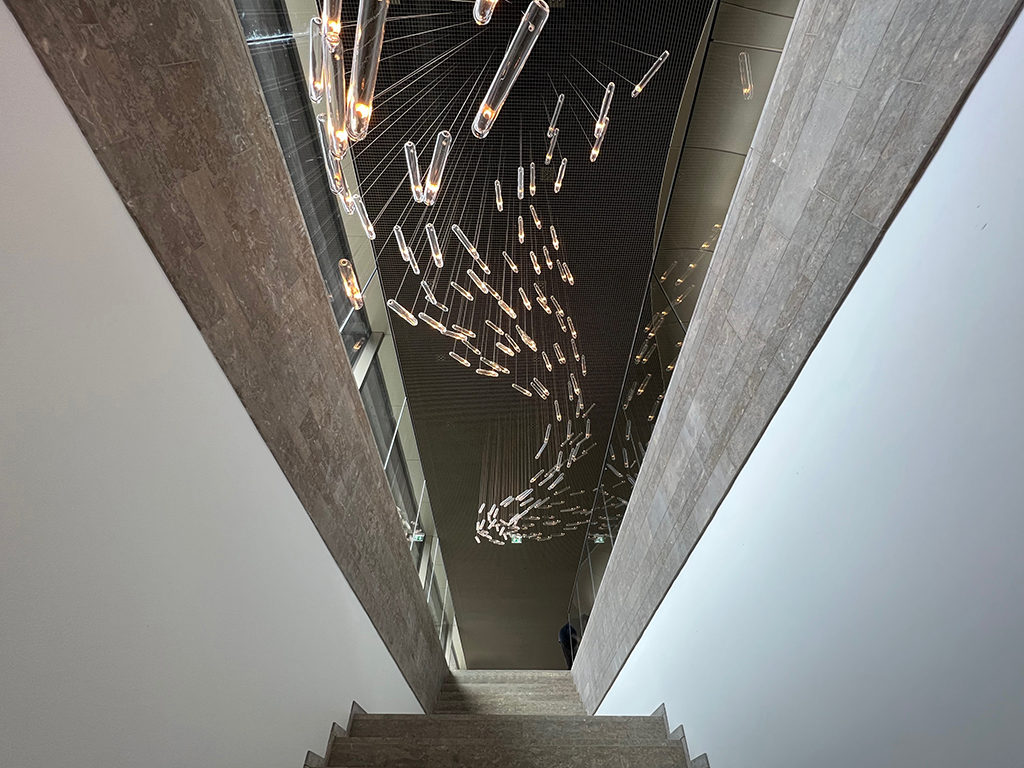Der Topographie angepasst, führt eine großzügige Treppe vom unteren Foyer hinauf zum oberen, dass sich zum Park hin öffnet. (Bild: Ursula Baus)