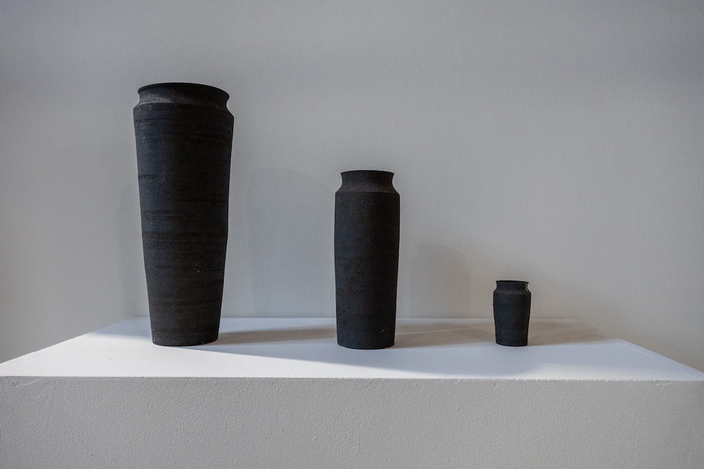 23.5.2025 Fellbach DEU Presserundgang über die 16. Kleinplastiktriennale in der Alten Kelter in Fellbach mit dem TiTel "Über. Lebensräume Habitate" ein Tag vor der Eröffnung - 11 Unknown Fields "Rare Earthenware". Die Vasen sind aus Giftschlamm geformt, der beim Abbau der Metalle und Seltenen Erden für die Produktion einer Autobatterie, eines Laptaps und eines Smartphones (vlnr) entsteht.