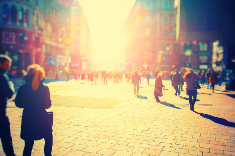 Crowd of anonymous people walking on sunset in the city streets